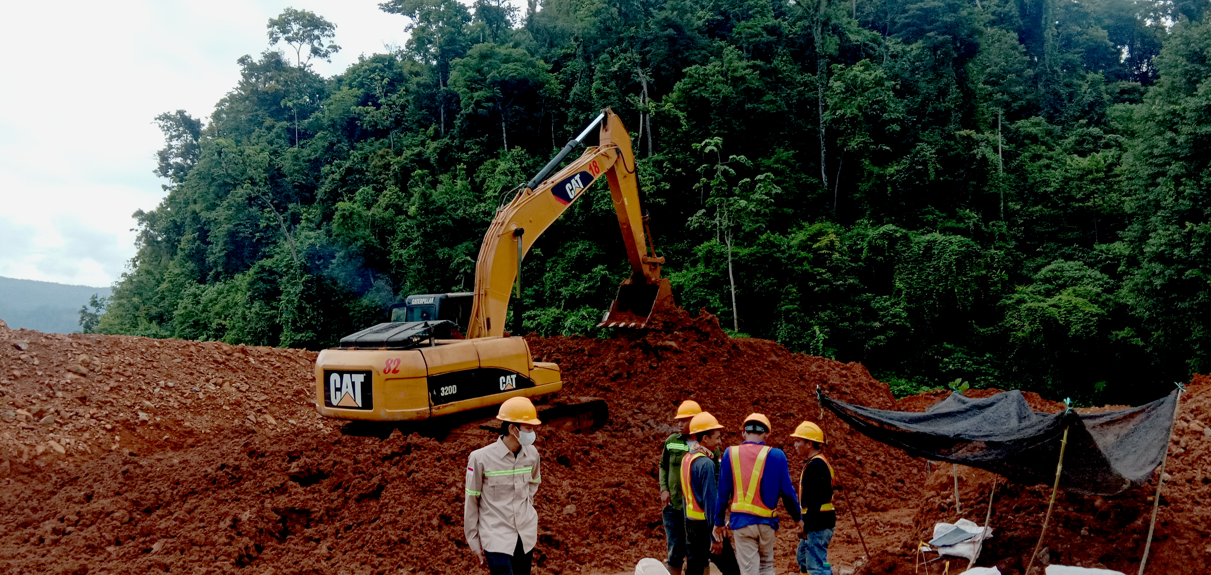 Yellow excavator on cliff